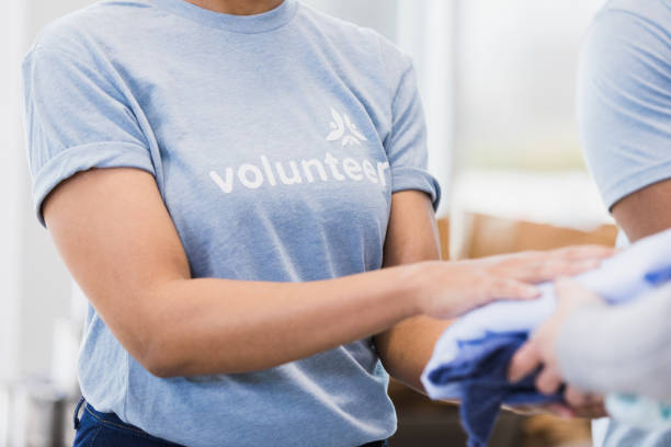 istock At thrift store, unrecognizable woman gives clothes to unrecognizable man 1389699627