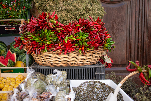 Red peppers hanging and  various vegetables in a market in Gallipoli, Salento, Puglia. Italy.