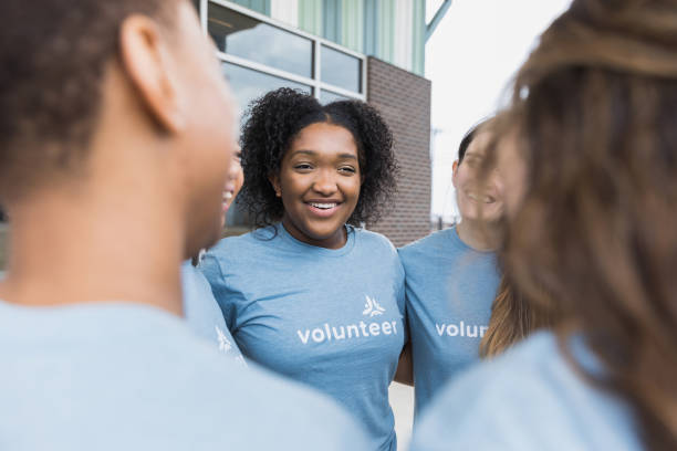istock In unity, volunteers stand together with arms around each other 1389700014