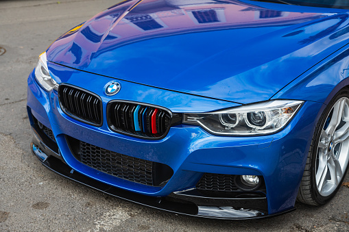 Side; Turkey – February 20 2022:   blue BMW 5-series , side glass, wheel, bumper and hood