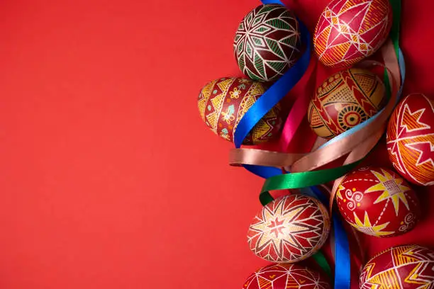 happy easter card. beautiful Easter egg Pysanka handmade on a red background"n