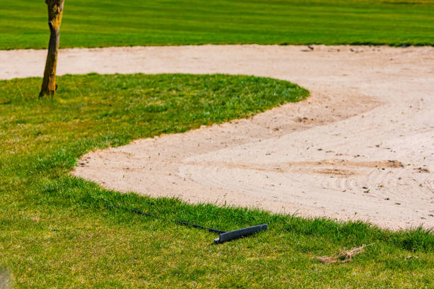 niemieckie pole golfowe z zadbanym trawnikiem i bunkrem z piasku z grabią do usuwania śladów - rules of golf zdjęcia i obrazy z banku zdjęć