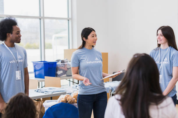 istock Female charity drive coordinator gestures while training volunteers 1389700943