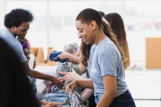 istock Diverse volunteers sort and fold donated clothing 1389702343