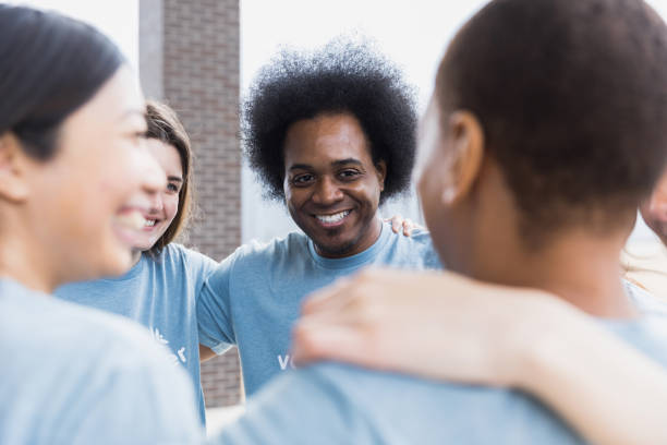 istock Happy multiracial group stands with arms on each other's shoulders 1389702356