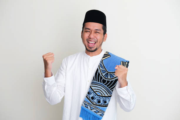 istock Moslem Asian man showing excited expression with both fist clenched 1389702638