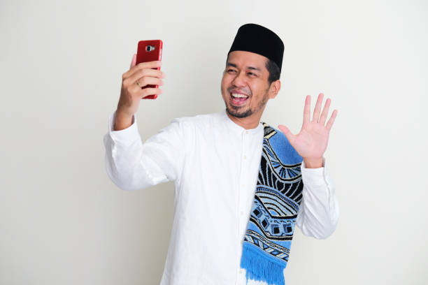 Moslem Asian man showing excited face expression during video call with his family during Ramadan celebration Moslem Asian man showing excited face expression during video call with his family during Ramadan celebration keluarga stock pictures, royalty-free photos & images