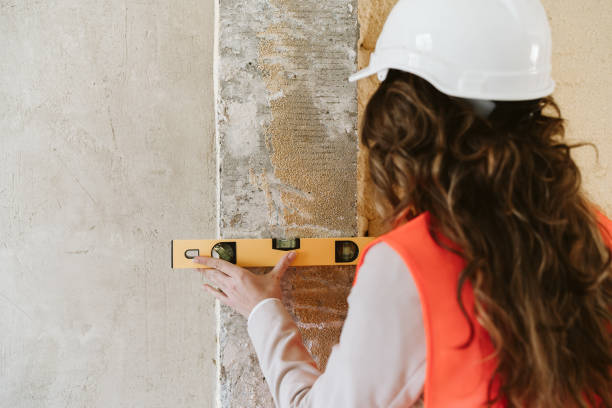 istock professional architect woman in construction site using level tool on wall. Home renovation 1389702950