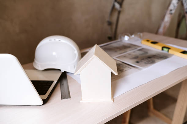 istock blueprints, protective helmet, laptop,house model and tools on architect workspace.Construction site 1389702957