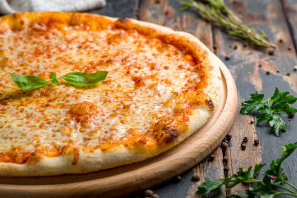 pizza italiana margherita (margarita) con queso, salsa de tomate y albahaca sobre mesa de madera vieja macro close up - cheese pizza fotografías e imágenes de stock
