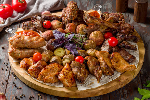 istock platter of different kebabs on board, chicken kekbab, lula kebab, lamb kebab, beef kebab, fried potatoes and mushrooms with tomato sauce macro close up 1389703684