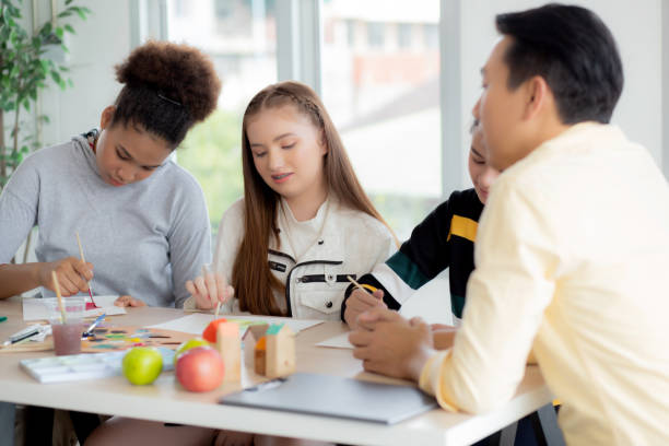 istock Group of student sitting and studying and learning drawing with teacher together in classroom at the school, pupils creativity and development for drawing in course, back to school, education concept. 1389704280