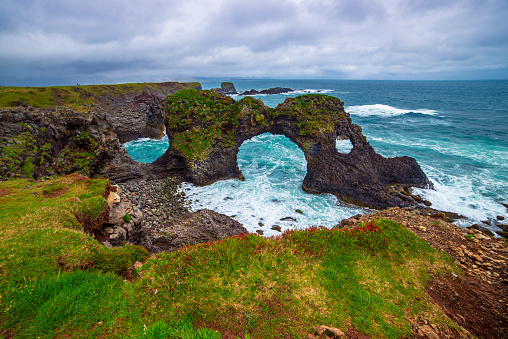 Amazing seascape, Gatklettur basalt rock arch at the volcanic cliff, Atlantic coast of Arnarstapi in the west of Iceland, natural travel background.