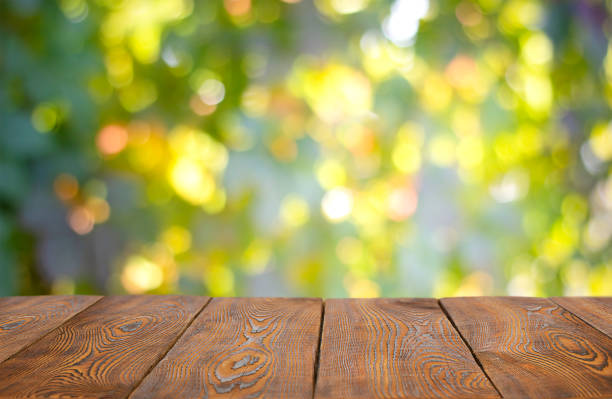 istock empty wooden table on green garden background. 1389706741