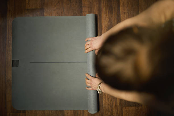 istock stylish female unfolding mat in modern green house 1389712902