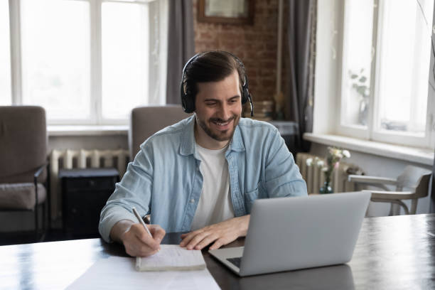 istock Happy student in earphones with mic attending virtual class 1389712994