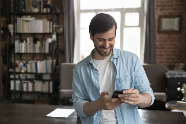 istock Happy joyful millennial business man using online app on smartphone 1389713024