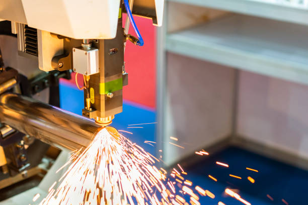 istock close up nozzle component of high precision cnc plasma laser cutting machine during engrave or perforate workpiece (pipe) and many sparks with automatic feed and rotation 