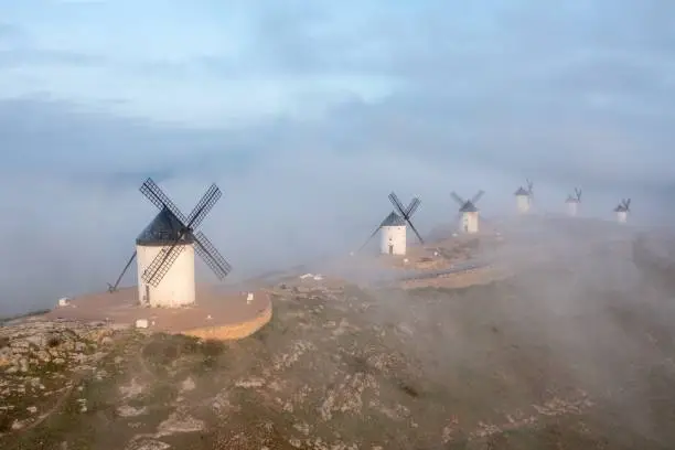 Typical old white Spanish windmills (Molinos appearing in Don Quijote) surrounded by a dry landscape in Consuegra, Toledo. Castilla la Mancha, Spain.
