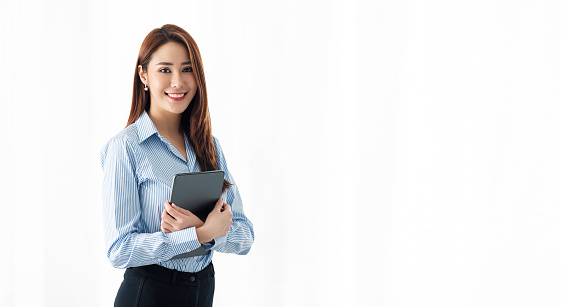 Portrait of Confident businesswoman holding tablet and smiling at the camera, isolated on white background.