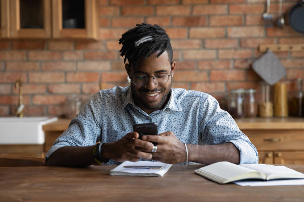 istock Happy Afro American guy chatting online, checking messages 1389719477