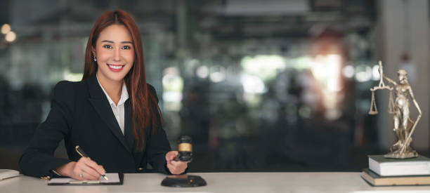 portrait of young female lawyer or attorney working in the office, smiling and looking at camera. - lawyer young adult suit expressing positivity imagens e fotografias de stock