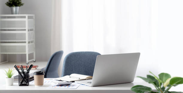 istock Laptop computer and document on wooden table in modern office room. 1389719741