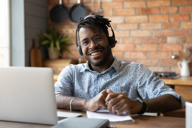 istock Happy mixed race student in headset satisfied with distance education 1389719781