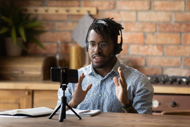 Engaged online coach giving virtual training, recording lecture on smartphone