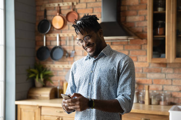 istock Happy trendy African American guy texting on smartphone 1389719869