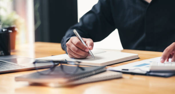 istock Businessman writing note and calculating business growth graph, analyzing and planning business strategy, financial, marketing and investment at office. 1389719898