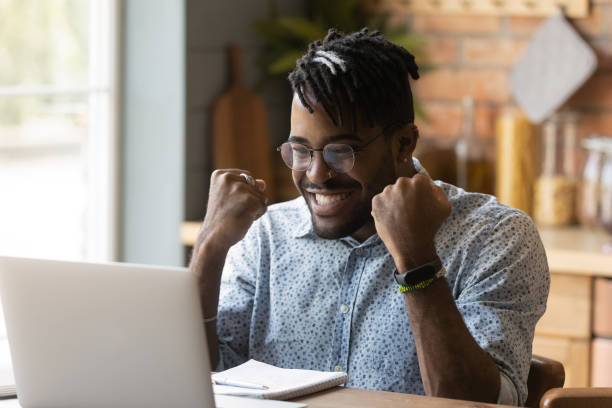 istock Happy student guy excited with good news, reading email letter 1389720923