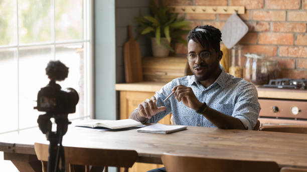 istock Happy Afro American blogger guy taking video on dslr camera 1389720924