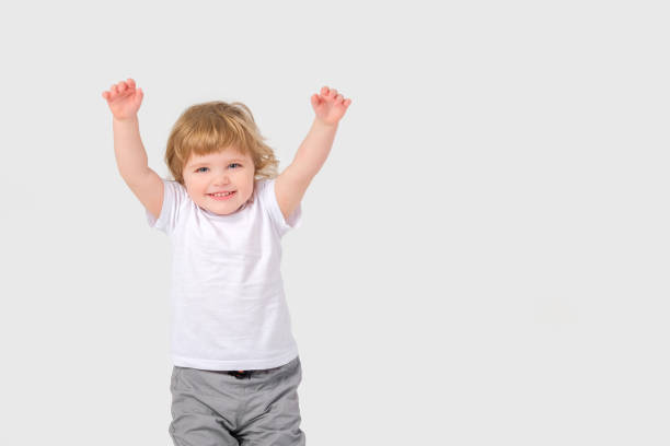 istock A small child holds his hands up and laughs. 1389721330