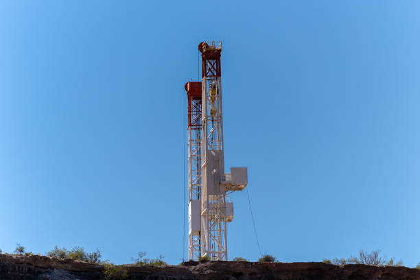 Dracking Drilling Rig Creating Gas or Oil Well Silhouetted at Dusk Under a Dramatic Sunset Sky