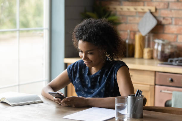 istock Smiling African mixed race student girl reading, texting, chatting online 1389726839