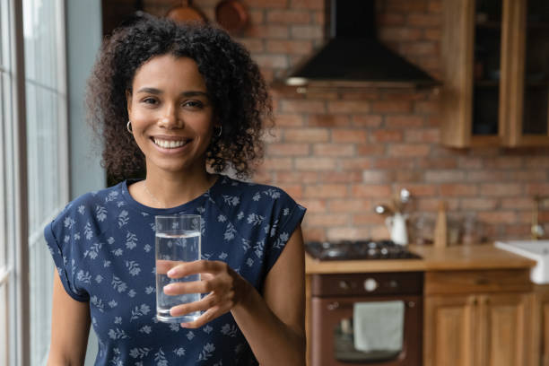 istock Happy young African mixed race woman drinking fresh water 1389726892