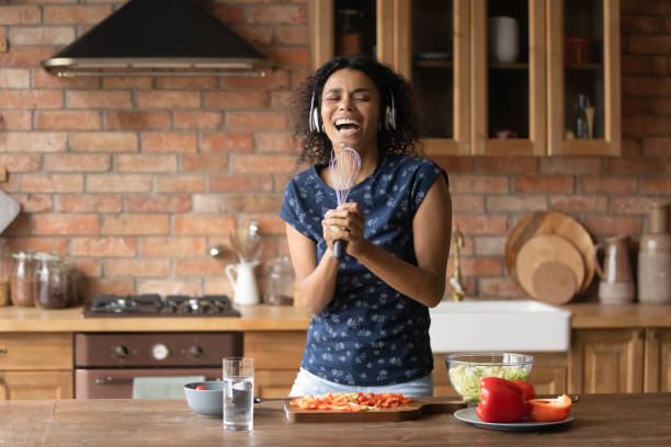 istock Happy excited young Black woman having fun in kitchen 1389726894