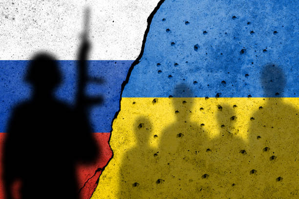Flag of Ukraine painted on a concrete wall with ukrainian civilians and a russian soldiers shadows. Russian military aggression stock photo