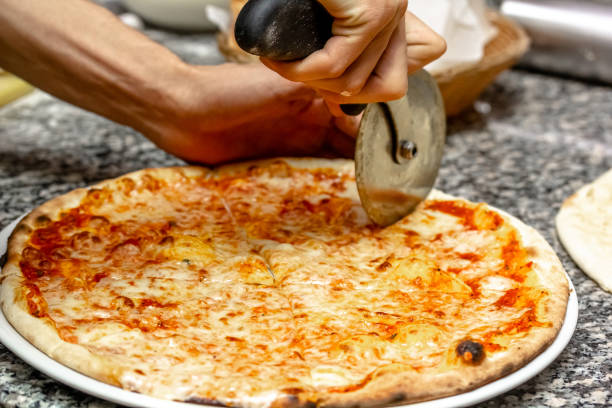 istock The chef cuts the pizza with a special round knife 1389735713