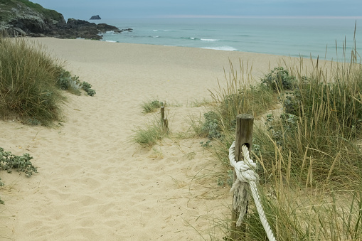 A well-groomed path to the sea with a fence made of marine ropes.