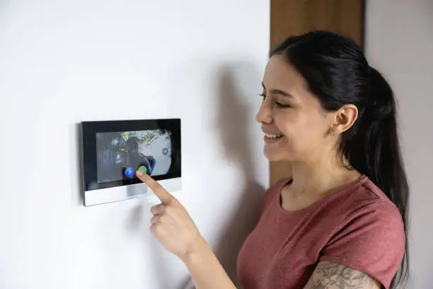 Photo of Woman at home using the intercom