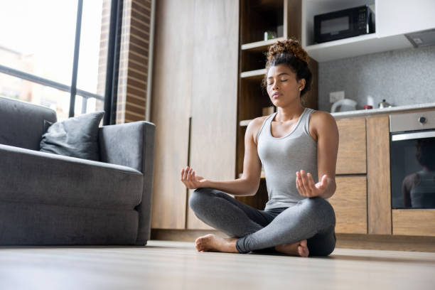istock Young woman meditating at home 1389740840