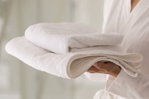 istock Female holds stack of fresh white towels, close up view 1389741129