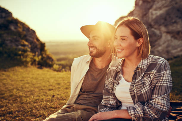 istock Smiling couple sitting together on meadow in mountains during summer vacations 1389742321