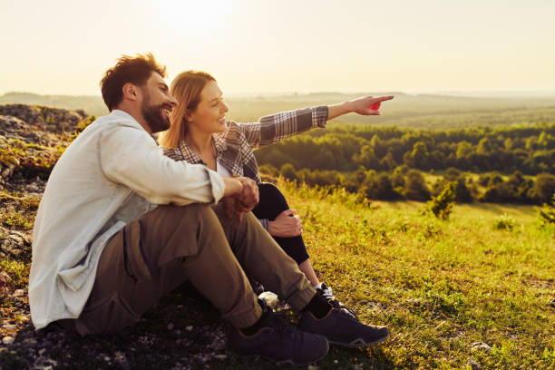 jovem casal sentados juntos assistindo paisagem rural durante caminhada de verão em jura, polônia - rural watch - fotografias e filmes do acervo