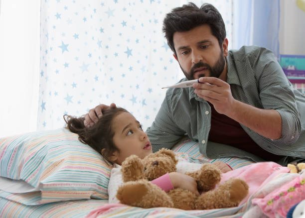 father taking little daughter temperature - child fever illness thermometer imagens e fotografias de stock