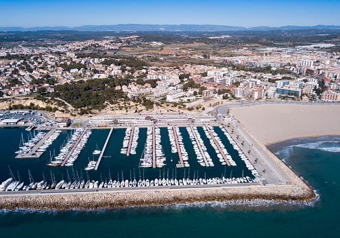View from drone of small tourist town of Torredembarra on Costa Daurada with yachts in marina, Catalonia, Spain