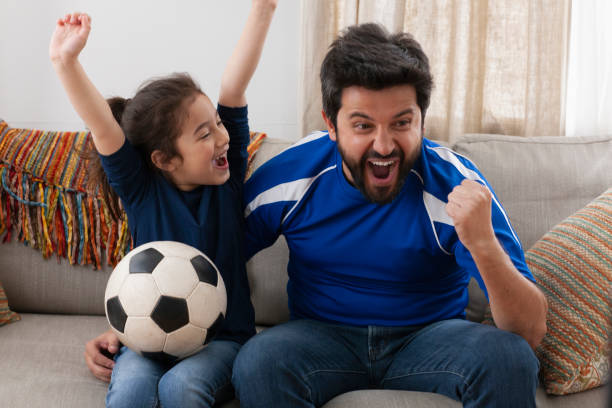 istock father watching sport game with daughter 1389745737