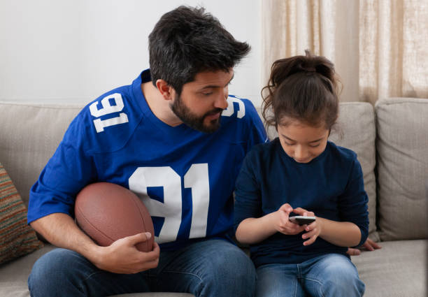 istock father watching sport game with daughter 1389745768